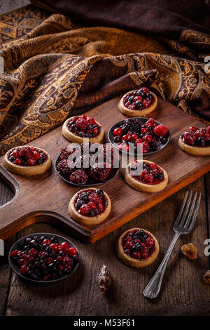 Tartelettes aux petits fruits rouges frais sur fond de bois Banque D'Images