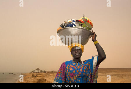 Le Mali. Tombouctou. Désert du Sahara. Sahel. Songhai, Songrai tribu. Femme retourne à la maison de lave-vaisselle dans la rivière Niger, faisant la vaisselle sur la tête. Banque D'Images