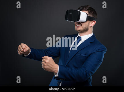 Heureux l'homme d'affaires en litige à l'intermédiaire de casque de réalité virtuelle et d'agir comme il conduit