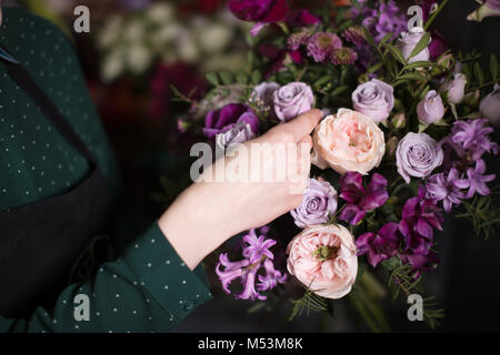 Jeune vendeur de toucher de belles roses au shop Banque D'Images