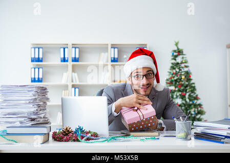 Young businessman célébrer Noël dans le bureau Banque D'Images