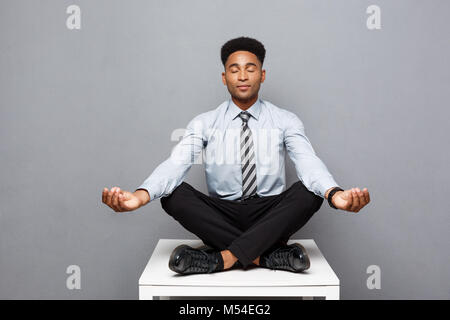 Concept d'affaires - portrait of african american businessman doing Meditation et Yoga yoga en avant de travailler. Banque D'Images