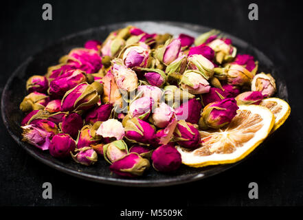 Rose Thé de bourgeons et de rondelles de citron sur la plaque sombre Banque D'Images