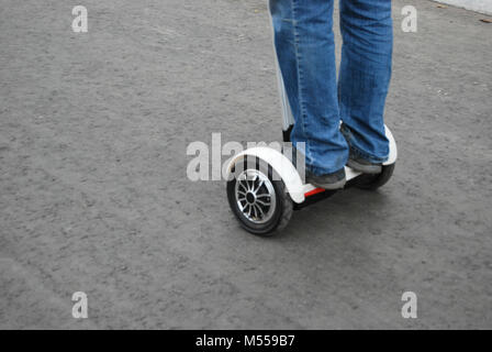 Les pieds d'un homme à cheval sur une rue de ville sur un Segway. Mode de vie sain. Banque D'Images