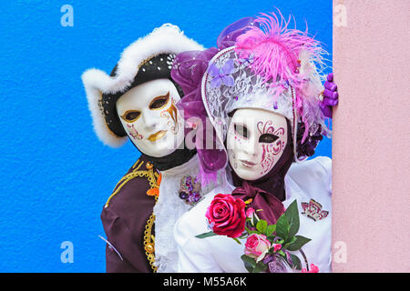 Un beau couple holding Flowers durant le Carnaval de Venise (Carnevale di Venezia) à Burano (Venise), Italie Banque D'Images