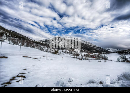 Les montagnes de neige sous un ciel nuageux bleu Banque D'Images