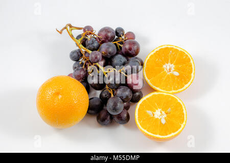 Les raisins et les oranges dans un fond blanc/orange/fruits/frais/raisin Banque D'Images