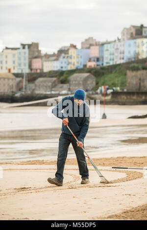 MARC TREANOR, sable, artiste travaillant sur l'une de ses énormes , mais éphémères, des motifs géométriques et graphisme sur une plage de sable à Tenby, West Wales UK, avant que la marée monte et se lave toute loin Banque D'Images