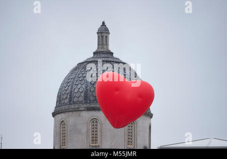 Trafalgar Square, Londres, Royaume-Uni. 20 février 2018. Le créateur de mode britannique d'Anya Hindmarch, projet public de design Chubby Coeurs, voit un cœur rouge gonflable géant voler au-dessus de Trafalgar Square sur un matin gris et pluvieux. Credit : Malcolm Park/Alamy Live News. Banque D'Images