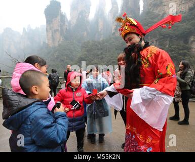 Zhang Jiajie. Feb 20, 2018. Un homme habillé comme Dieu de la richesse donne des paquets de lucky red kids à Wulinyuan dans Zhangjiajie, endroit pittoresque du centre de la Chine la province du Hunan, le 20 février 2018, le cinquième jour de la Nouvelle Année lunaire chinoise qui est censé être l'anniversaire du dieu de la richesse. Le "dieu de la richesse" est censé apporter fortune aux gens. Credit : Wu Yongbing/Xinhua/Alamy Live News Banque D'Images