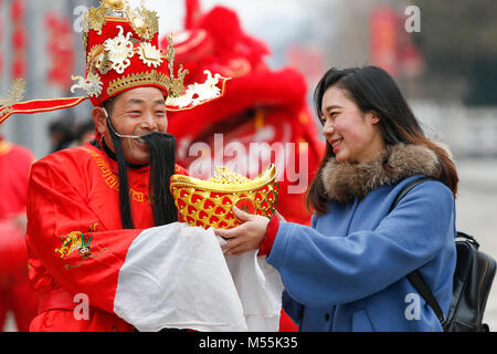 Taizhou. Feb 20, 2018. Un homme habillé comme le dieu de la richesse envoie présenter à un touriste à Taizhou, dans la province du Jiangsu en Chine de l'Est, le 20 février 2018, le cinquième jour de la Nouvelle Année lunaire chinoise qui est censé être l'anniversaire du dieu de la richesse. Le "dieu de la richesse" est censé apporter fortune aux gens. Credit : Tang Dehong/Xinhua/Alamy Live News Banque D'Images