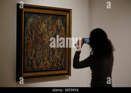 Londres, Royaume-Uni. 20 Février, 2018. Un employé utilise un téléphone portable à côté d'une peinture à l'huile 'L'incindie I (I) le feu" par l'artiste Maria Helena Vieira da Silva à la maison Christie's à Londres Le mardi 20 février 2018. L'œuvre, d'une valeur estimative de 1,5 million de livres sterling, seront vendus à l'après-guerre et l'Art Contemporain vente du soir le 6 mars. Credit : Luke MacGregor/Alamy Live News Banque D'Images
