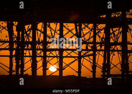 Pays de Galles Aberystwyth UK, le mardi 20 mars 2018 Royaume-Uni : Météo : Le soleil se couche, encadré de façon spectaculaire derrière la jetée de Aberystwyth, sélectionne les silhouettes de certains des dizaines de milliers d'étourneaux minuscule qu'ils se perchent pour la nuit, entassés pour plus de chaleur et de sécurité, sur les poutres et les poutres sous l'ère victorienne distinctif de la ville jetée en bord de l'un des rares gîtes urbains au Royaume-Uni, le Crédit : Keith morris/Alamy Live News Banque D'Images