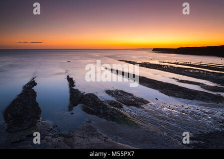 Kimmeridge, Dorset, UK. 20 février 2018. Météo britannique. Un spectaculaire coucher du soleil orange à Kimmeridge Bay sur la côte jurassique du Dorset à marée basse révélant les célèbres corniches Kimmeridge. Crédit photo : Graham Hunt/Alamy Live News. Banque D'Images