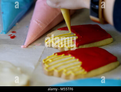 Davenport, Iowa, États-Unis. Feb 11, 2018. Glaçage royal jaune est utilisé pour décrire les formes de frites dans une boîte Biscuits au sucre, Dimanche 11 Février, 2018, au cours d'un cookie decorating catégorie détenues à Oh So Sweet par Tiphanie situé au 314, rue Main à Davenport. Crédit : John Schultz/Quad-City Times/ZUMA/Alamy Fil Live News Banque D'Images