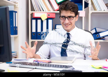 Employé attaché et enchaîné à son bureau avec chaîne Banque D'Images