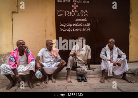 Les hommes assis dans la rue et parler à Varanasi, Inde Banque D'Images