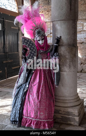 Dame en costume et masque très décoré, debout contre le pilier durant Carnaval de Venise (Carnaval de Venise) Banque D'Images