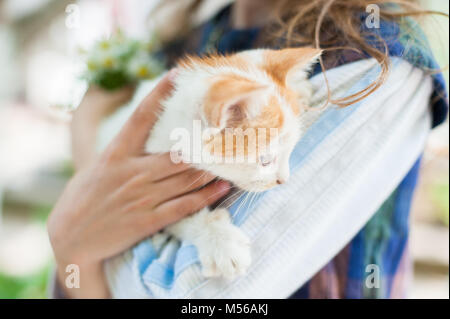 Little girl holding a kitten doucement dans ses bras Banque D'Images