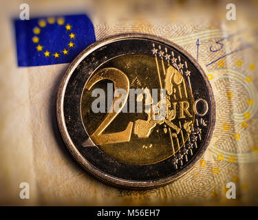 Pièce de deux euros. Pièce sur un arrière-plan flou de la dénomination de pièce de deux euros. Monnaie de l'Union européenne. Arrière-plan de billets. Banque D'Images