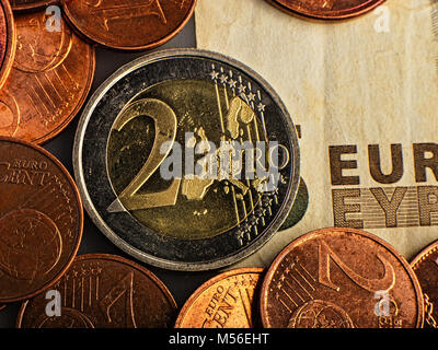 Pièce de deux euros. Pièce sur un arrière-plan flou de la dénomination de pièce de deux euros. Monnaie de l'Union européenne. Arrière-plan de billets. Banque D'Images