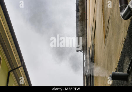 La vapeur chaude venant d'une maison d'habitation à pipe par temps froid Banque D'Images