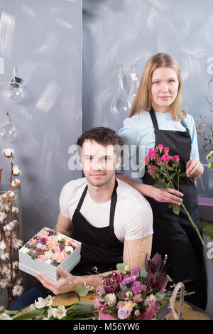 Deux jeunes fleuristes travaillant au magasin de fleurs Banque D'Images