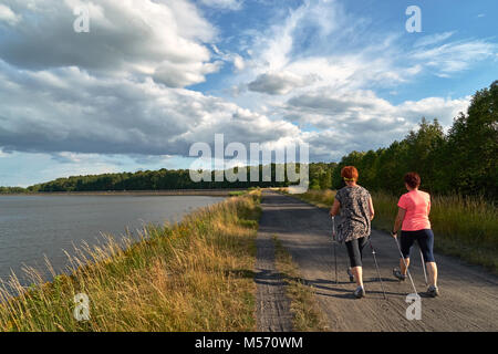 Marche nordique - une marche avec deux poteaux de femmes le long de la Lake Banque D'Images