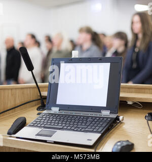Ordinateur portable et micro sur la tribune in lecture hall plein de participants à la conférence. Banque D'Images