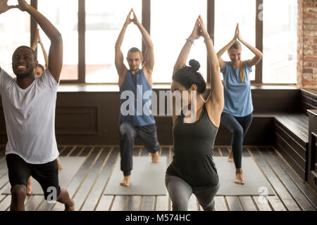 Le yoga en groupe studio, diverses personnes faisant des exercices avec l'instru Banque D'Images