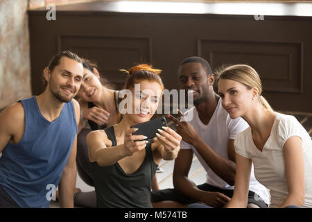 Jolie femme sportive holding phone groupe prenant de tra selfies Banque D'Images