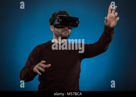 Bel homme portant des lunettes de la technologie de l'avenir ,fond bleu, Studio shot Banque D'Images