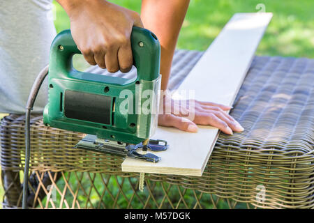 Femme avec planche en bois de sciage scie électrique Banque D'Images