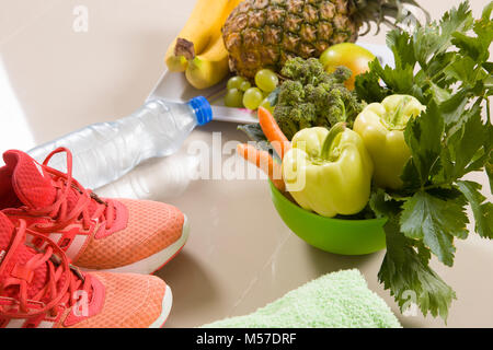 Sport chaussures sport, l'eau, ruban à mesurer et de pommes sur fond blanc. Vue de dessus d'équipements sportifs. Vie saine et une alimentation saine notion Banque D'Images