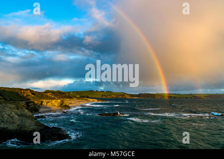 Un arc-en-ciel dynamique dans l'ensemble des arches de la baie de St Austell et la petite ville côtière de Polkerris dans Cornwall Banque D'Images