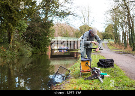 Pêcheur solitaire mettant son matériel isolé sur le chemin de halage après la pêche du matin dans le canal du Royaume-Uni. Pêche à la ligne au Royaume-Uni. Banque D'Images