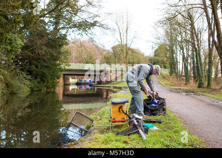 Pêcheur solitaire mettant son matériel isolé sur le chemin de halage après la pêche du matin dans le canal du Royaume-Uni. Pêche à la ligne au Royaume-Uni. Banque D'Images