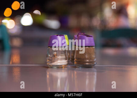 Close-up of salt and pepper shaker sur table au restaurant.Le sel et moulins à poivre sur table en bois sur fond bleu. Banque D'Images