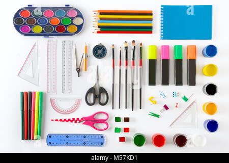 Ensemble de matériel scolaire sur fond blanc. Le bloc-notes, crayons, peinture, pinceaux, ciseaux. Vue d'en haut. Banque D'Images