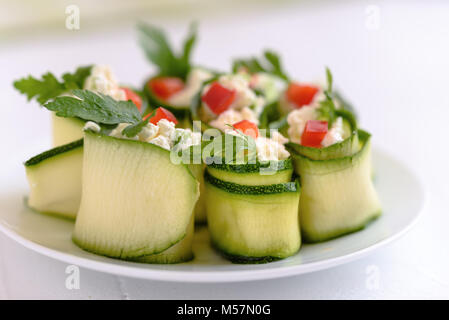 Rouleaux de courgettes farcies au fromage et ciboulette et paprika rouge. Banque D'Images