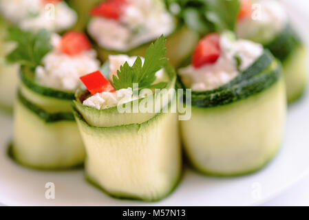 Rouleaux de courgettes farcies au fromage et ciboulette et paprika rouge. Banque D'Images