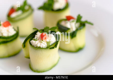 Rouleaux de courgettes farcies au fromage et ciboulette et paprika rouge. Banque D'Images