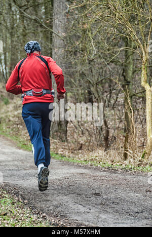 Runner dans la forêt, vêtu d'un manteau sport rouge Banque D'Images
