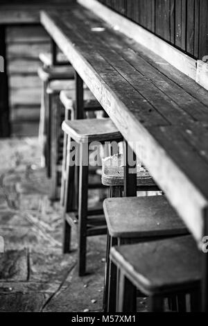 Très vieille chaise en bois patiné et tabourets Banc, Selective Focus sur la plus endommagée, noir et blanc photographie de style classique, la nostalgie des LO Banque D'Images