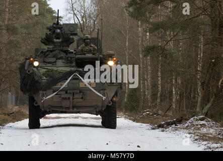 Des soldats américains affectés à la Troupe de fer, 3e Escadron, 2e régiment de cavalerie, leur manœuvre Stryker à leur position de défense tout en participant à l'exercice de formation de multinationales à Puma une gamme près de la zone d'entraînement Bemowo Piskie, Pologne, le 19 février, 2018. Ces soldats font partie de l'unique, composé de groupe de combat multinationales des États-Unis, du Royaume-Uni, de la Croatie et de soldats roumains qui servent avec la 15e Brigade mécanisée polonaise comme une force de dissuasion dans le nord-est de la Pologne à l'appui de l'OTAN vers l'amélioration de la présence. (U.S. Photo de l'armée par la CPS. Andrew McNeil/ 22e Détachement des affaires publiques Mobiles Banque D'Images