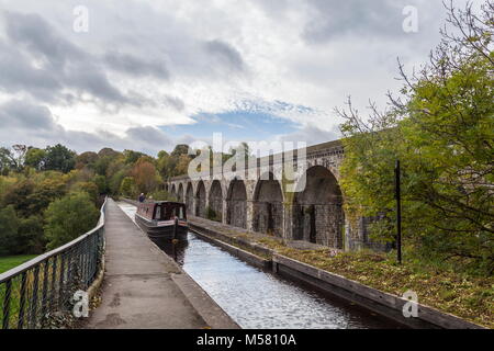 Un bateau étroit passe de l'Angleterre dans le pays de Galles à travers l'Aqueduc de Chirk pendant le début de l'automne. Le viaduc construit Henry Robertson est au-dessus du canal Banque D'Images