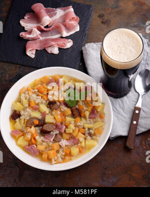 Un plat traditionnel irlandais Dublin dorloter avec des saucisses et de la bière sur une table Banque D'Images