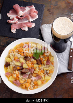 Un plat traditionnel irlandais Dublin dorloter avec des saucisses et de la bière sur une table Banque D'Images