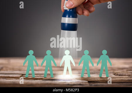 Portrait of businessman's hand holding lampe sur le papier l'homme représentant le recrutement à fond gris Banque D'Images