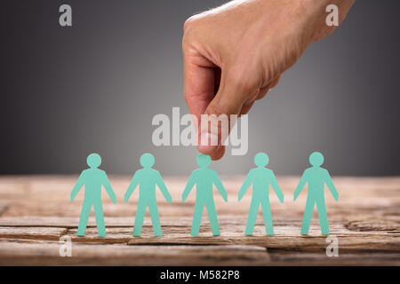 Portrait of businessman's hand picking livre vert l'homme représentant le recrutement à fond gris Banque D'Images